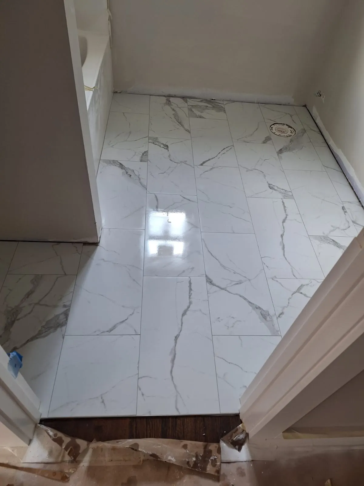 Glossy marble-look porcelain tile floor in a bathroom, Kings Mountain Tile project in North Carolina